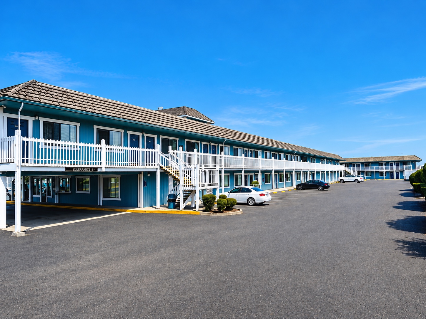 Seabird Lodge exterior in daylight, with blue siding, white balcony railings, and on-site parking