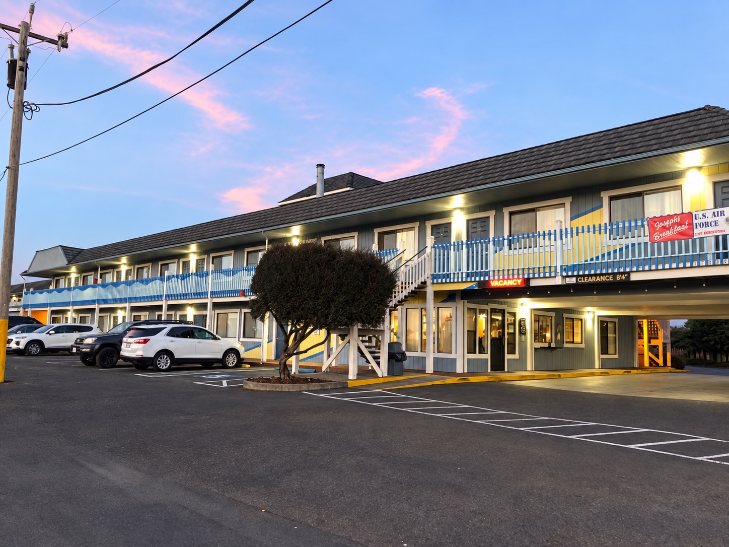 Seabird Lodge entrance at dusk, with warm exterior lights and guest parking