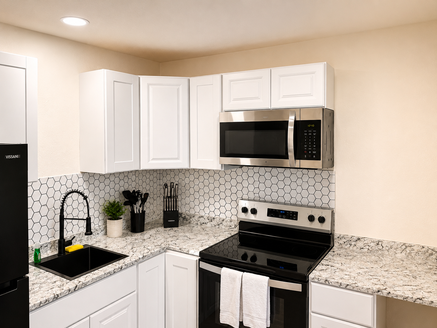 Single Queen Kitchenette with stove, microwave, sink, and refrigerator